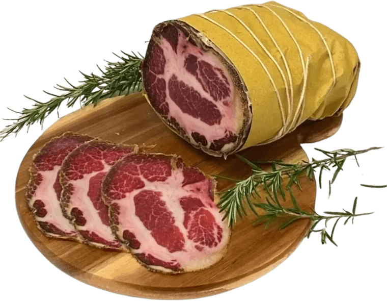 Sicilian cured capocollo, sliced on a wooden board with rosemary
